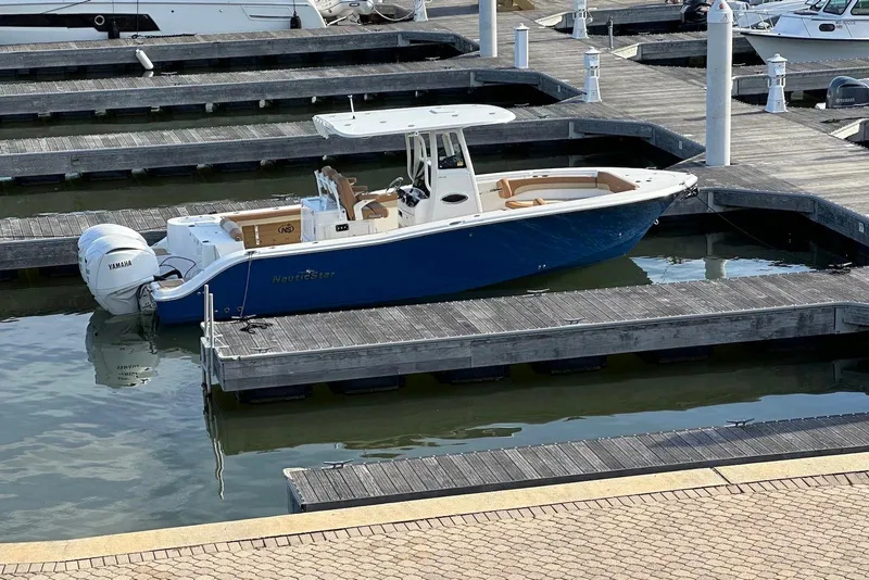 The Image of 2023 NauticStar 28 XS boat docked at marina with Yamaha engines. - 0