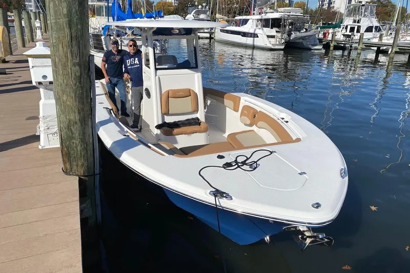 Slide: The Image of 2023 NauticStar 28 XS boat docked at marina with two people onboard. - 3