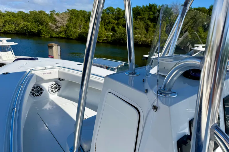Slide: The Image of 2024 Contender 25 Tournament boat with sleek design, docked by a scenic waterway. - 13