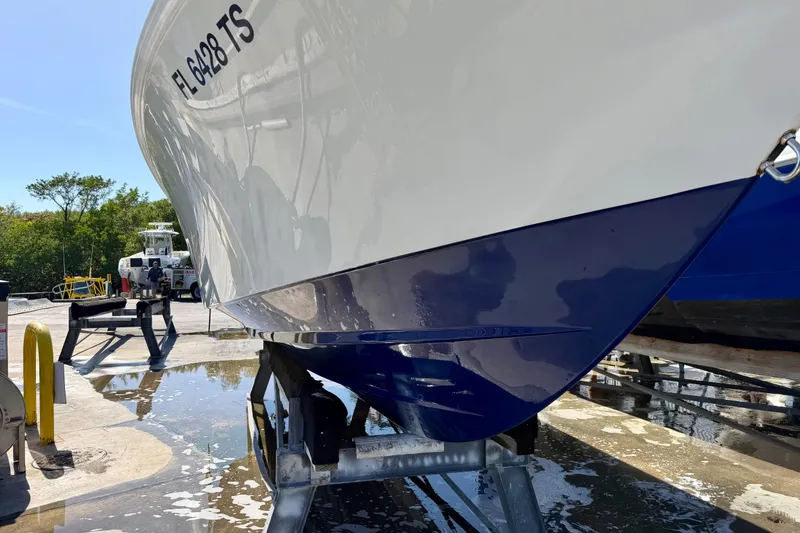 Slide: The Image of 2024 Contender 25 Tournament boat on trailer, hull close-up, sunny day. - 18