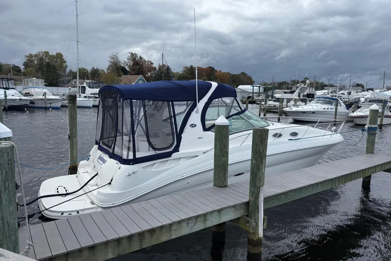 The Image of 2003 Sea Ray 320 Sundancer docked at marina under cloudy skies. - 0