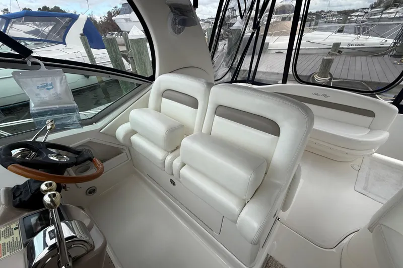 Slide: The Image of 2003 Sea Ray 320 Sundancer cockpit with white leather seats and steering wheel. - 13
