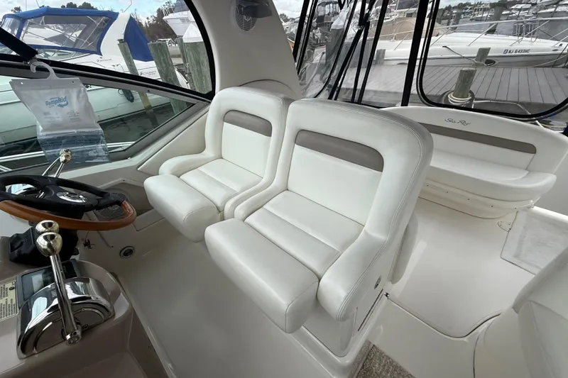Slide: The Image of 2003 Sea Ray 320 Sundancer cockpit with white leather seats and steering wheel. - 14