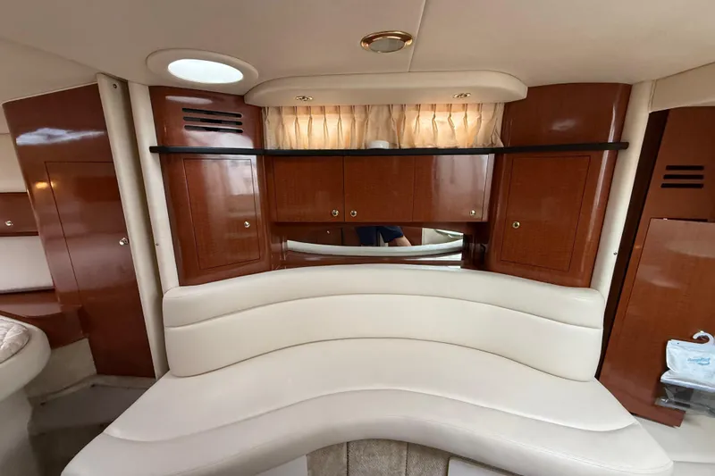 Slide: The Image of Interior of 2003 Sea Ray 320 Sundancer with curved seating and wooden cabinetry. - 18