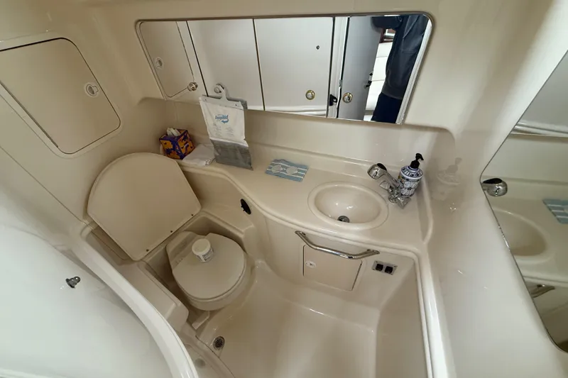 Slide: The Image of Bathroom interior of 2003 Sea Ray 320 Sundancer yacht, featuring sink and toilet. - 21