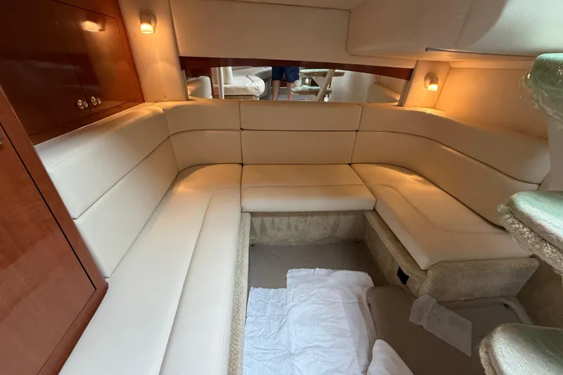 Slide: The Image of Luxurious interior of 2003 Sea Ray 320 Sundancer with cream leather seating and warm lighting. - 31