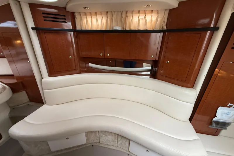 Slide: The Image of Luxurious interior of 2003 Sea Ray 320 Sundancer with curved seating and wooden cabinetry. - 32
