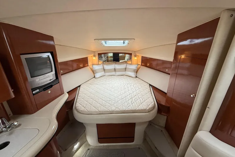 Slide: The Image of Luxurious 2003 Sea Ray 320 Sundancer cabin with cozy bed and elegant wood finishes. - 34