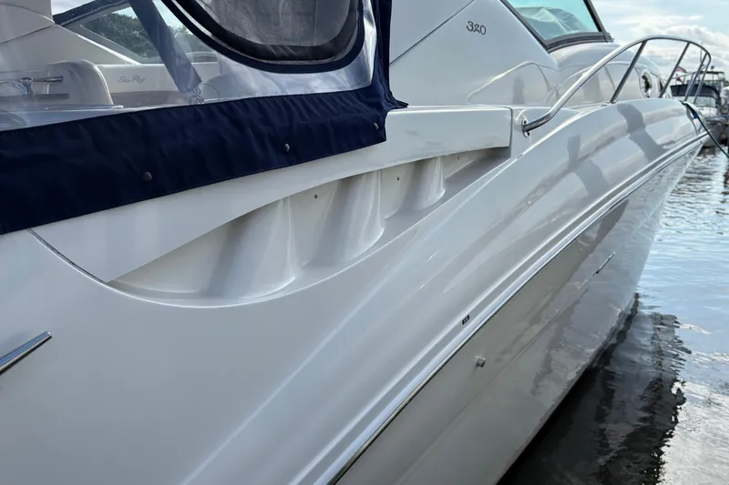 Slide: The Image of 2003 Sea Ray 320 Sundancer boat docked, showcasing sleek white hull and elegant design. - 38
