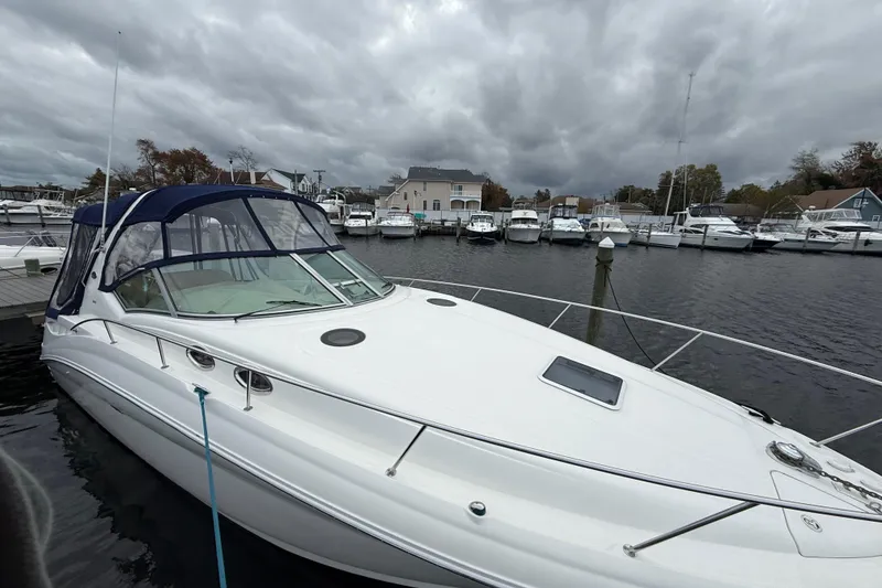 Slide: The Image of 2003 Sea Ray 320 Sundancer docked at a marina under cloudy skies. - 4