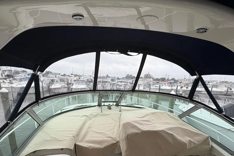 Slide: The Image of 2003 Sea Ray 320 Sundancer interior view at marina, covered seating area. - 55