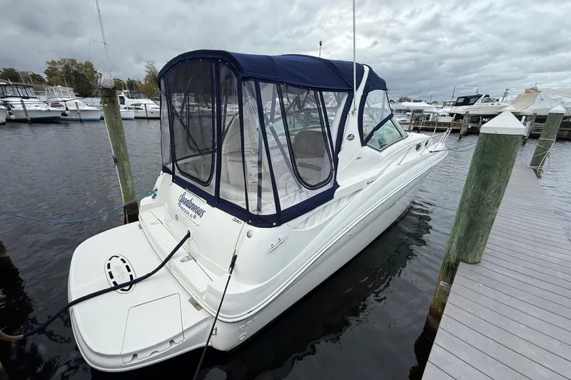 Slide: The Image of 2003 Sea Ray 320 Sundancer docked at marina under cloudy skies. - 6