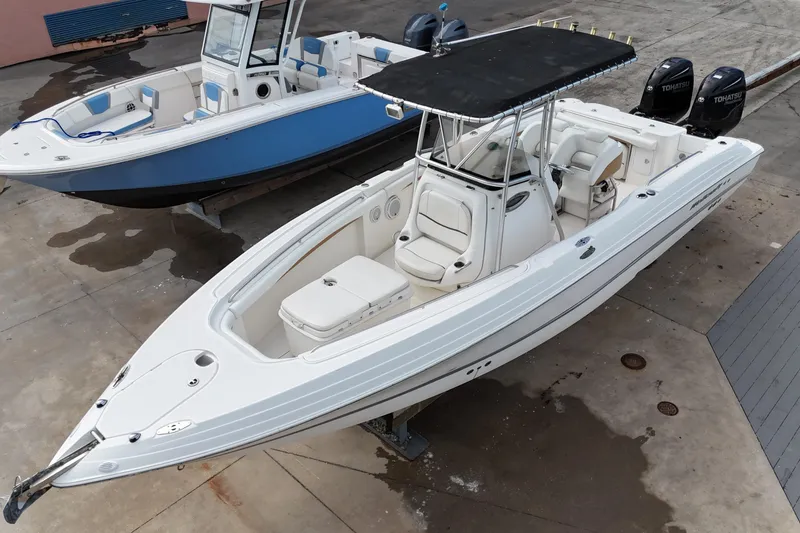 The Image of 2003 Wellcraft 29 CCF boat with dual engines, docked alongside another vessel. - 0