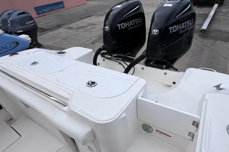 Slide: The Image of 2003 Wellcraft 29 CCF boat with dual Tohatsu outboard engines, docked on concrete. - 18