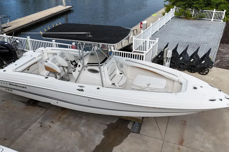 Slide: The Image of 2003 Wellcraft 29 CCF boat docked, featuring sleek design and spacious seating. - 2