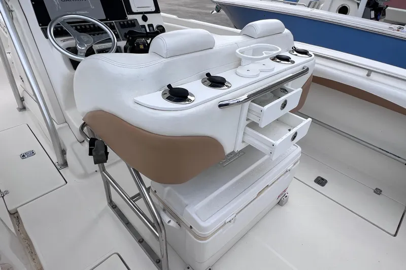 Slide: The Image of 2003 Wellcraft 29 CCF boat interior with helm, storage drawers, and seating. - 24