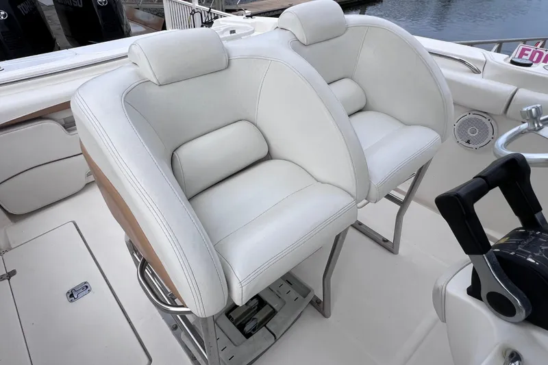 Slide: The Image of 2003 Wellcraft 29 CCF boat interior with white cushioned seats and steering controls. - 25