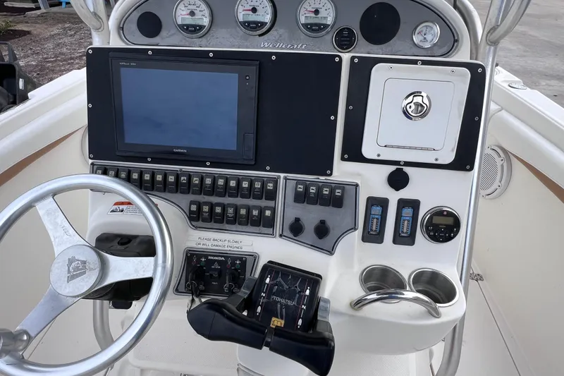 Slide: The Image of 2003 Wellcraft 29 CCF boat dashboard with steering wheel and control panel. - 27
