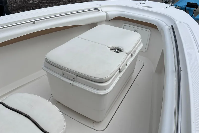 Slide: The Image of 2003 Wellcraft 29 CCF boat interior with cushioned seating and storage compartment. - 34
