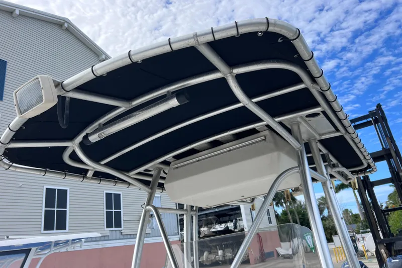 Slide: The Image of 2003 Wellcraft 29 CCF boat T-top with blue canvas under a partly cloudy sky. - 54