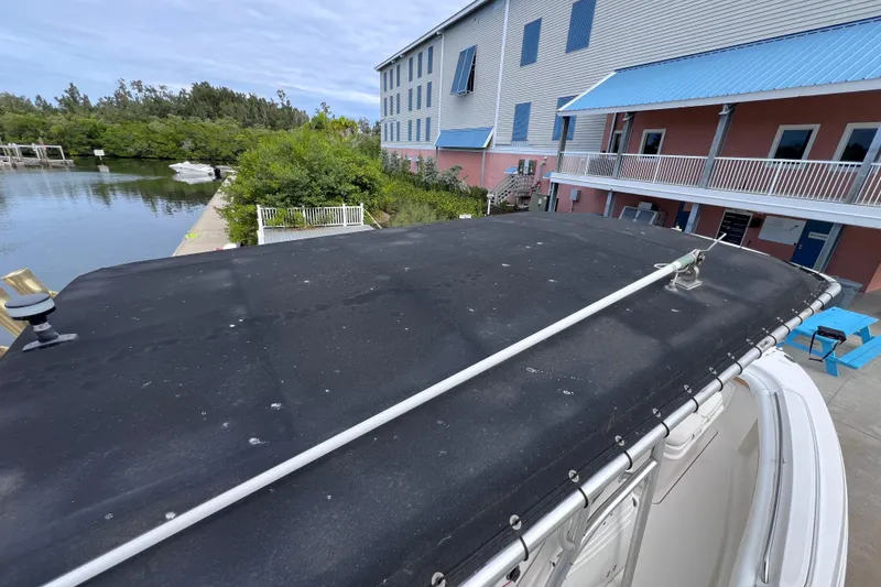 Slide: The Image of 2003 Wellcraft 29 CCF boat docked near waterfront building with blue awnings. - 57