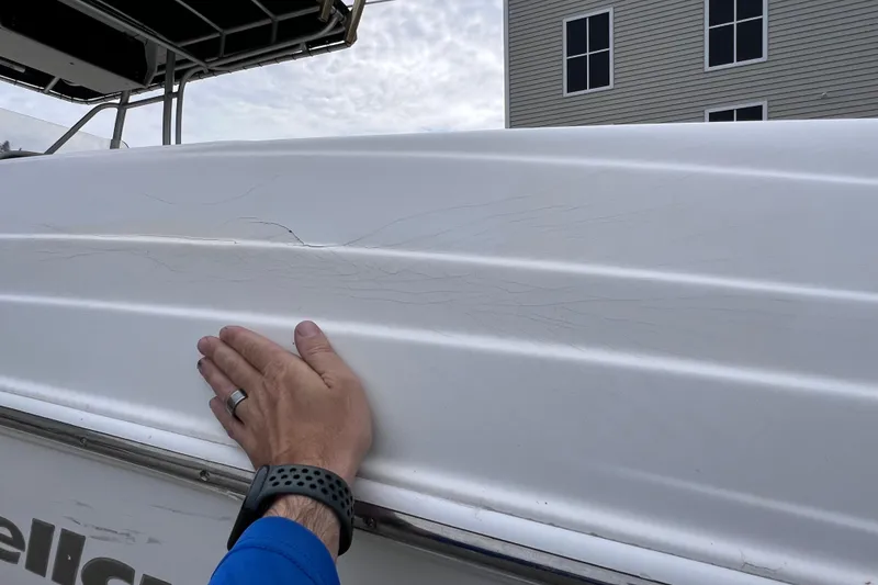 Slide: The Image of Hand inspecting crack on 2003 Wellcraft 29 CCF boat hull. - 59