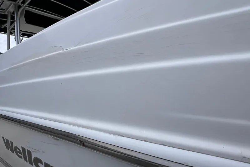 Slide: The Image of Side view of a 2003 Wellcraft 29 CCF boat with visible scratches. - 60