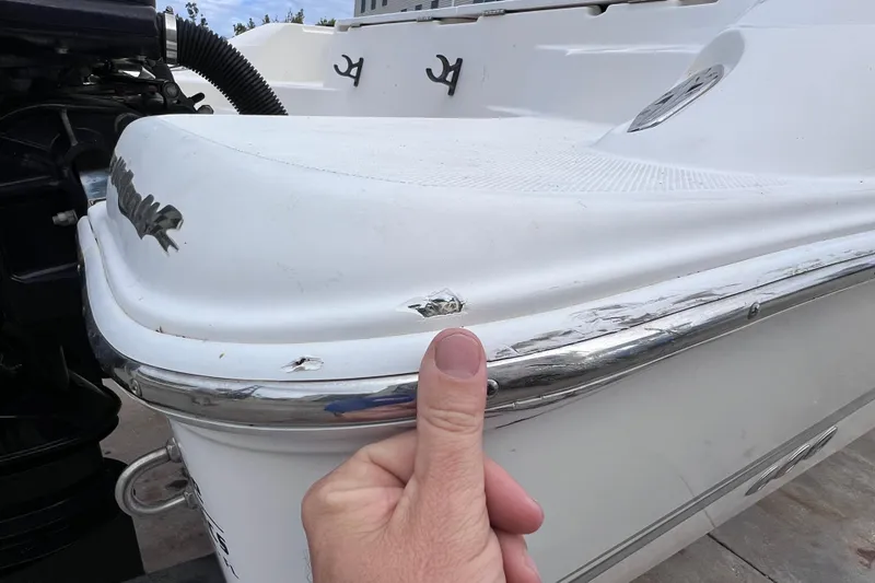 Slide: The Image of 2003 Wellcraft 29 CCF boat with visible hull damage and chrome trim. - 61