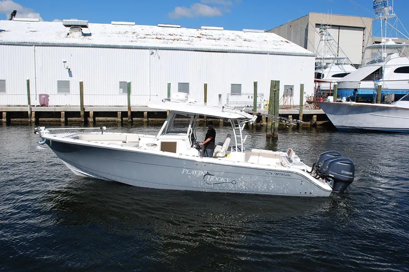 The Image of 2019 Cobia 344 Center Console boat docked, featuring twin Yamaha engines. - 0
