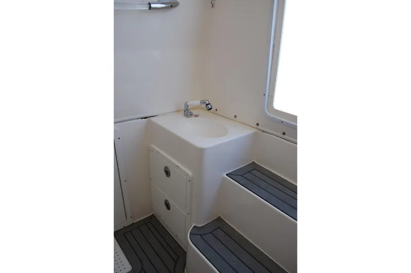 Slide: The Image of 2019 Cobia 344 Center Console boat interior with sink and storage compartments. - 15