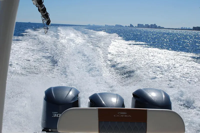 Slide: The Image of 2019 Cobia 344 Center Console boat cruising on open water, leaving a wake behind. - 18