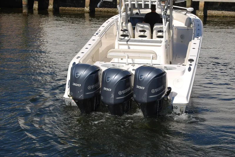 Slide: The Image of 2019 Cobia 344 Center Console boat with triple Yamaha 300 engines on water. - 2