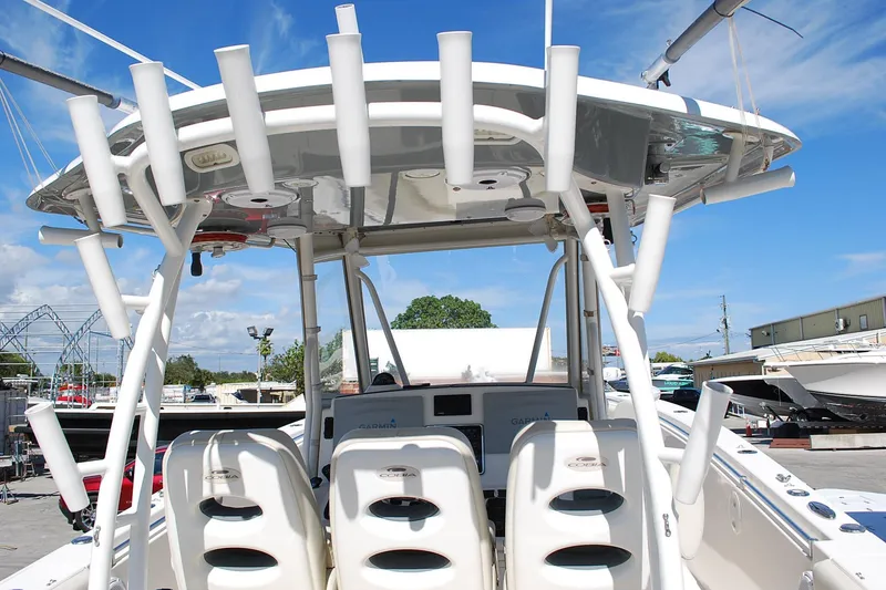 Slide: The Image of 2019 Cobia 344 Center Console boat with rod holders and seating, docked under blue sky. - 20
