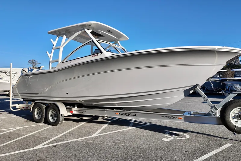 Slide: The Image of 2026 Sea Fox 288 Traveler boat on trailer, parked in a lot under clear blue sky. - 25
