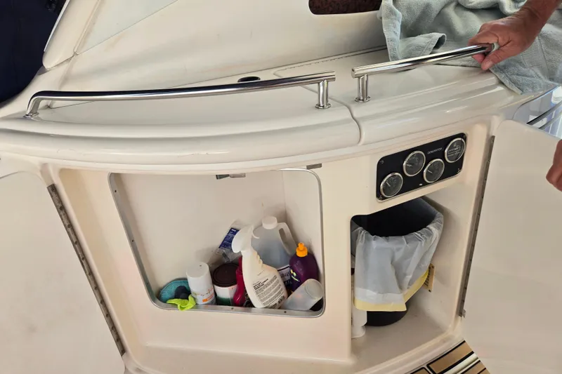 Slide: The Image of Open storage compartment on 2000 Sea Ray 540 Sundancer yacht with cleaning supplies and gauges. - 26