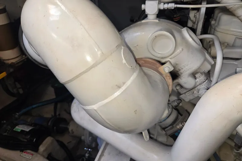Slide: The Image of Engine component of a 2000 Sea Ray 540 Sundancer boat, featuring white piping and connections. - 70