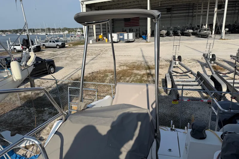 Slide: The Image of 2019 Nautitech 40 Open catamaran docked near boatyard with trailers and vehicles. - 15