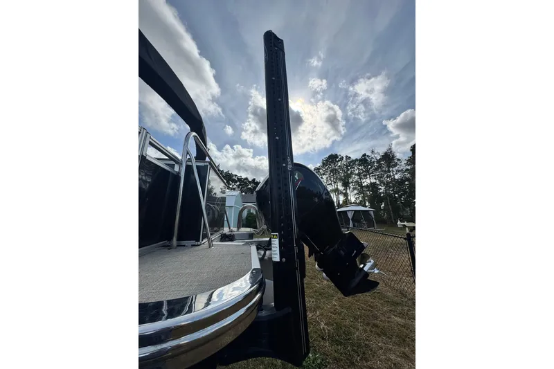 Slide: The Image of 2022 Avalon GS Rear Fish 25' boat with motor, under a partly cloudy sky. - 17