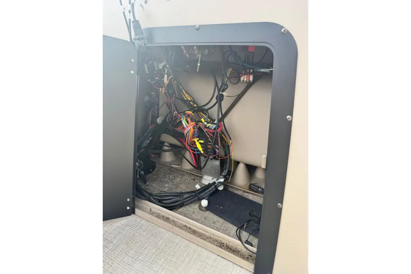 Slide: The Image of 2022 Avalon GS Rear Fish 25' boat wiring compartment with visible cables and connections. - 24