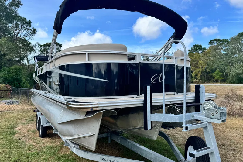 Slide: The Image of 2022 Avalon GS Rear Fish 25' pontoon boat on trailer, parked outdoors. - 26