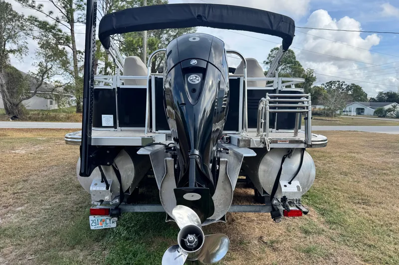 Slide: The Image of 2022 Avalon GS Rear Fish 25' pontoon boat with outboard motor, parked on grass. - 27