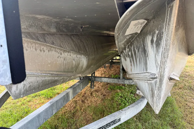 Slide: The Image of 2022 Avalon GS Rear Fish 25' boat hull on trailer, grassy background. - 35