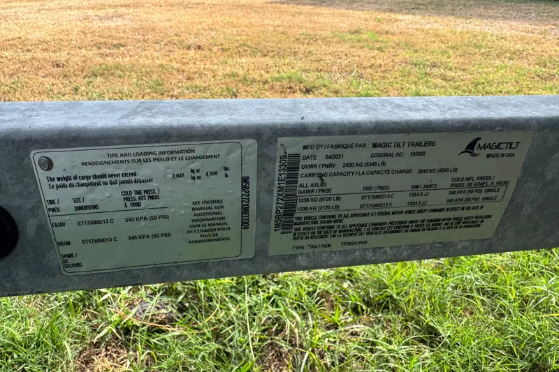 Slide: The Image of Trailer tire and loading information label on grass, Avalon GS Rear Fish - 25', 2022 model. - 36