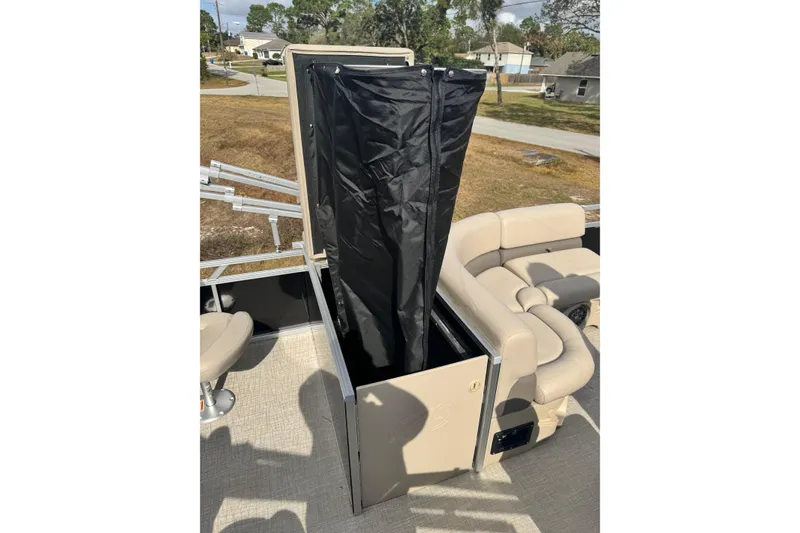 Slide: The Image of 2022 Avalon GS Rear Fish 25' boat with open storage compartment and beige seating. - 9