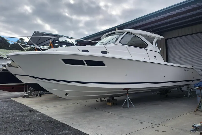 The Image of 2026 Pursuit OS 355 Offshore boat cruising on a cloudy day near a bridge. - 0