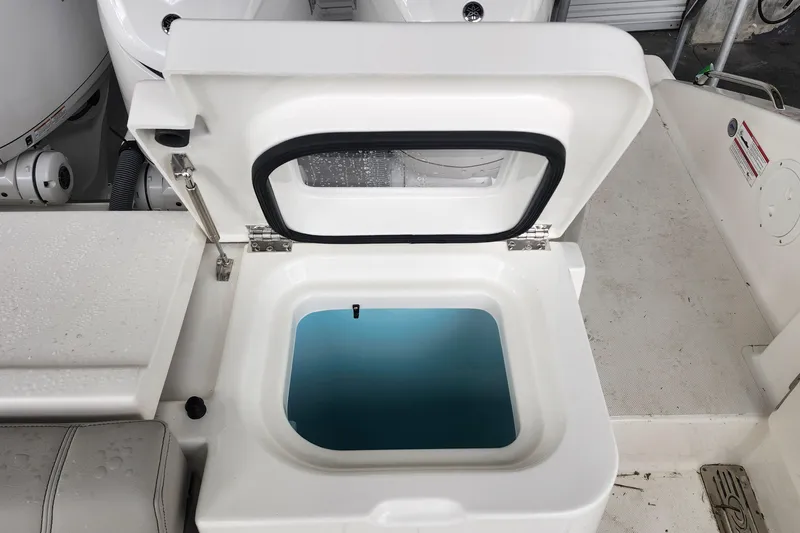 Slide: The Image of Open storage compartment on 2026 Pursuit OS 355 Offshore boat, featuring stainless steel handle. - 11