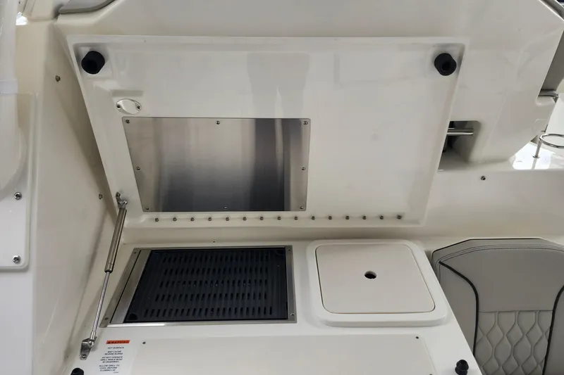 Slide: The Image of Engine compartment of 2026 Pursuit OS 355 Offshore boat, showing mechanical components and fire extinguisher. - 15