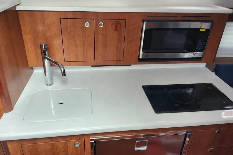 Slide: The Image of 2026 Pursuit OS 355 Offshore cabin with elegant wood table and comfortable seating. - 25