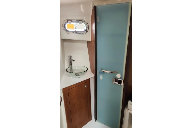 Slide: The Image of 2026 Pursuit OS 355 Offshore cabin with elegant wood table and plush seating. - 26