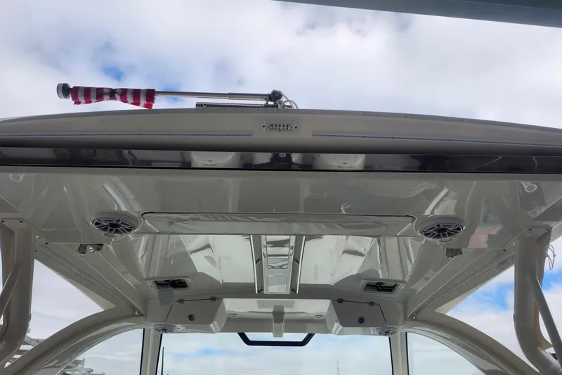 Slide: The Image of 2026 Pursuit OS 355 Offshore boat on stands in a covered storage area. - 3